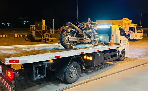 Motocicleta transportada na plataforma do guincho durante a noite